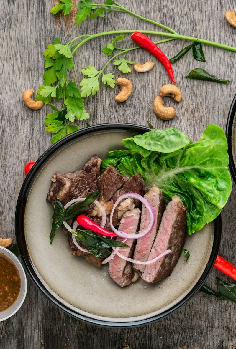 Chef searing gourmet steak cuts on flat-top grill