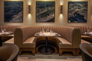 Intimate booth seating with ocean-wave artwork