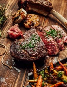 Dry-aged bone-in ribeye with roasted vegetables