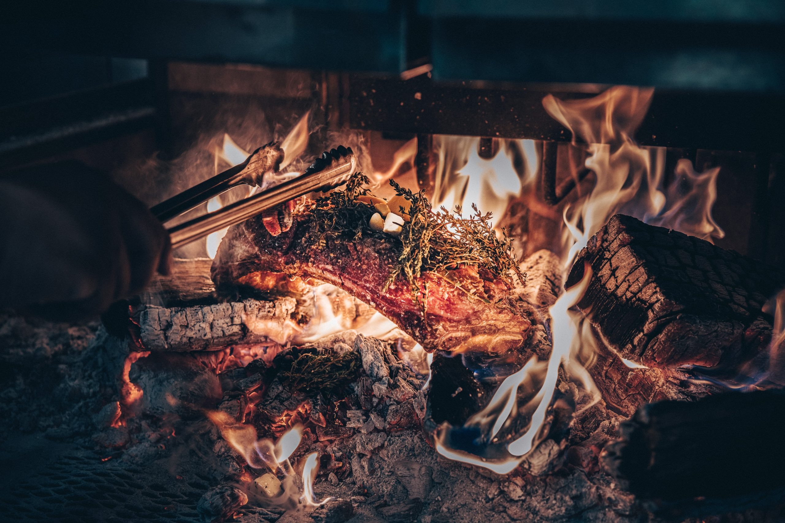 Wood-fired grill with steak and herbs at The Rex Seaside Steakhouse